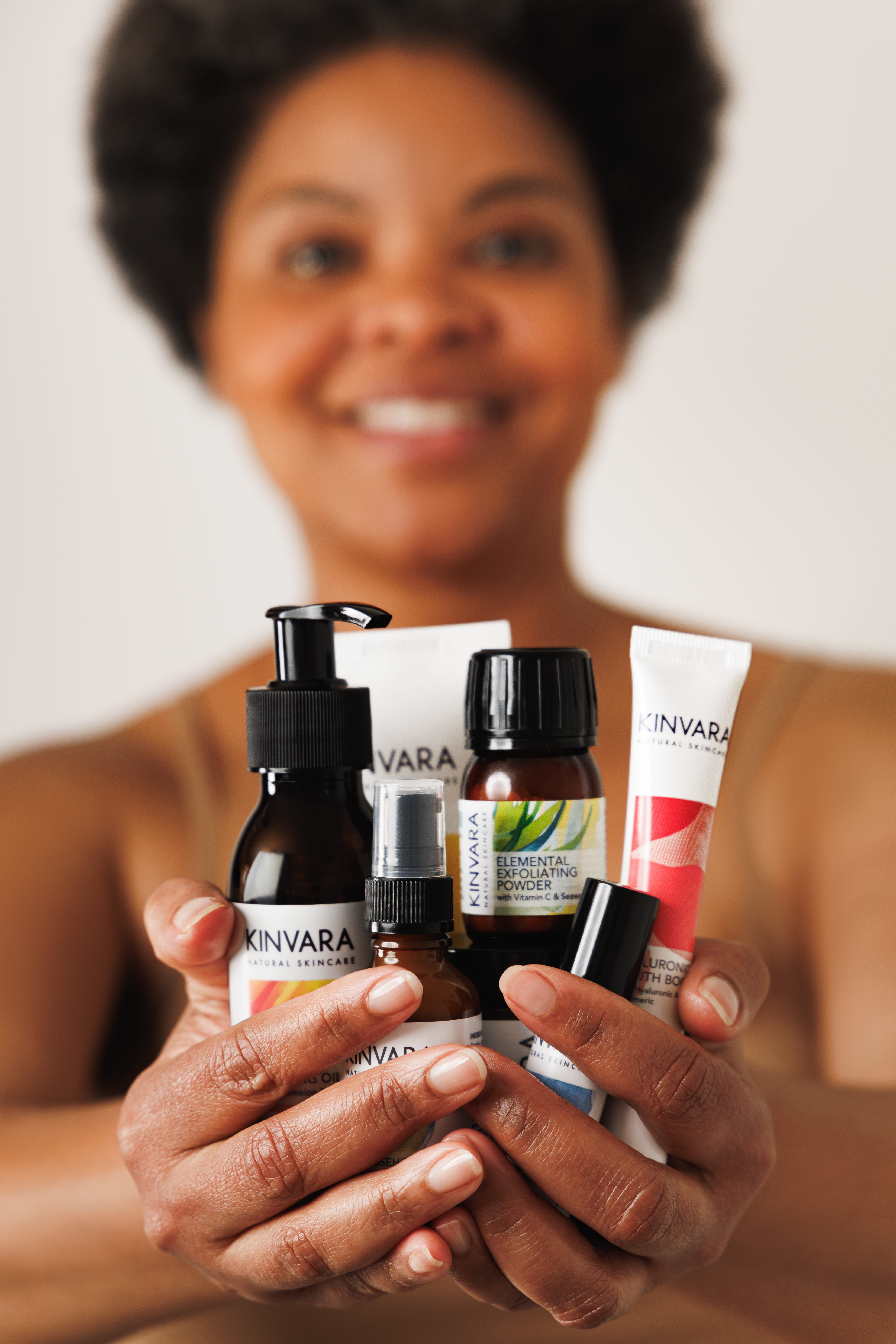 A person holding various Kinvara Skincare products.