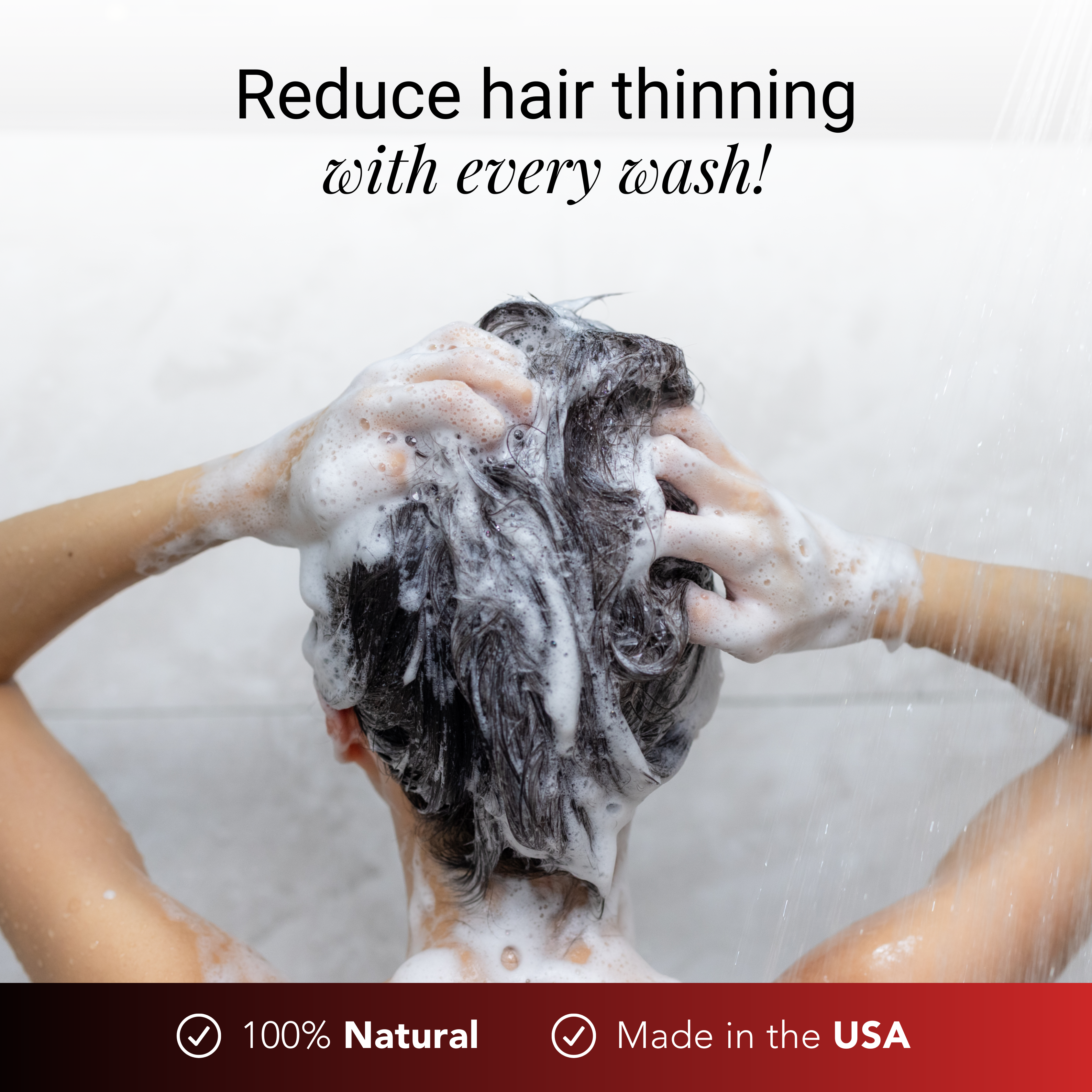 Person washing their hair, lathered with shampoo, under running water.