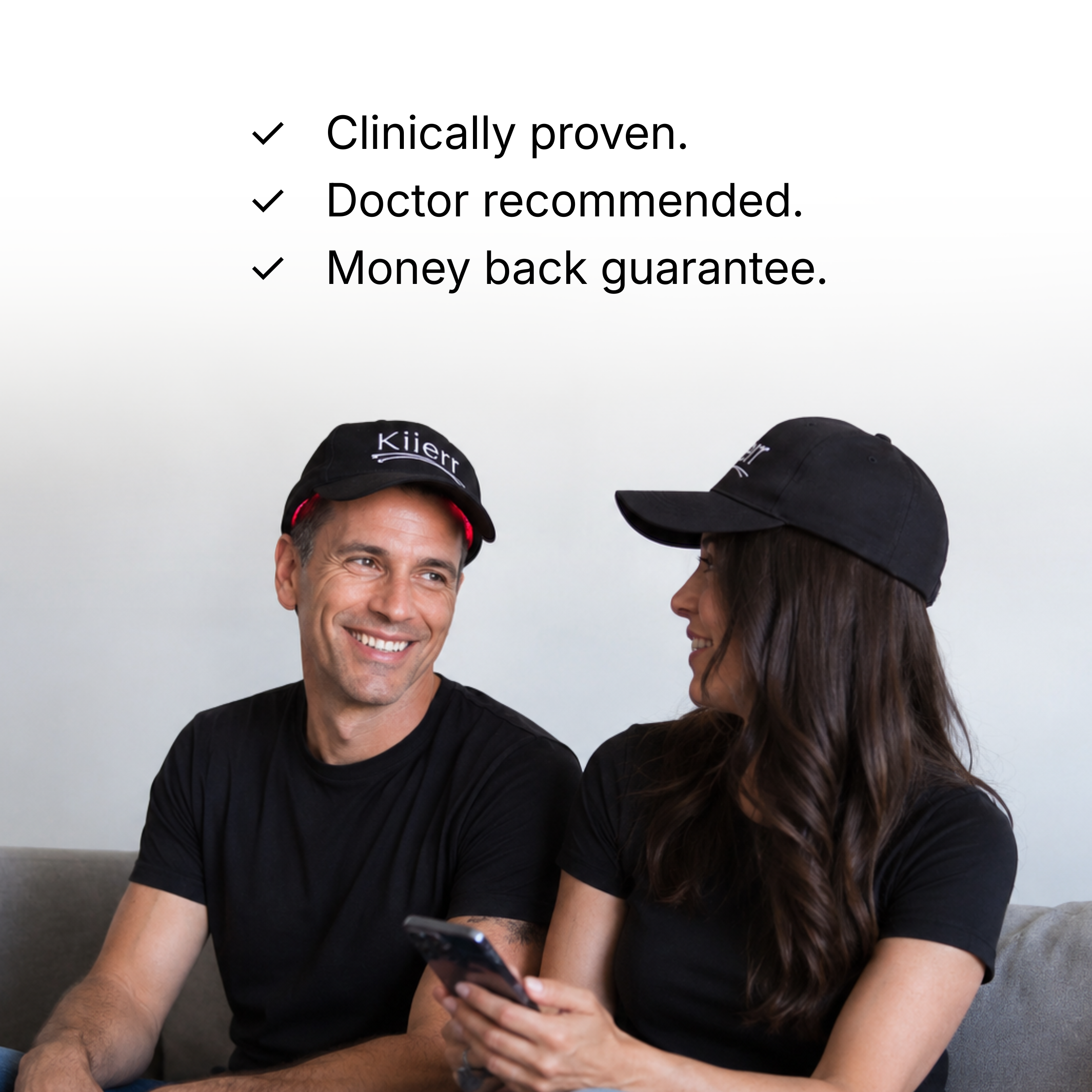 A man and a woman wearing black Kiierr hats sit on a couch below a list of guarantees.