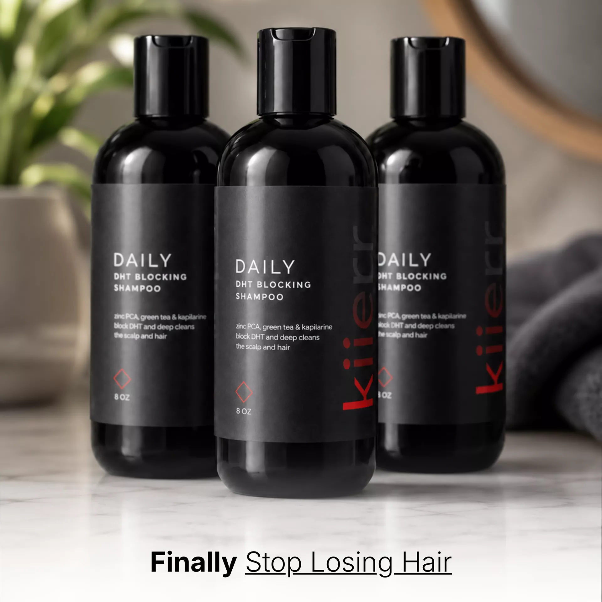Three black bottles of Daily DHT Blocking Shampoo sitting on a marble countertop in a bathroom setting.