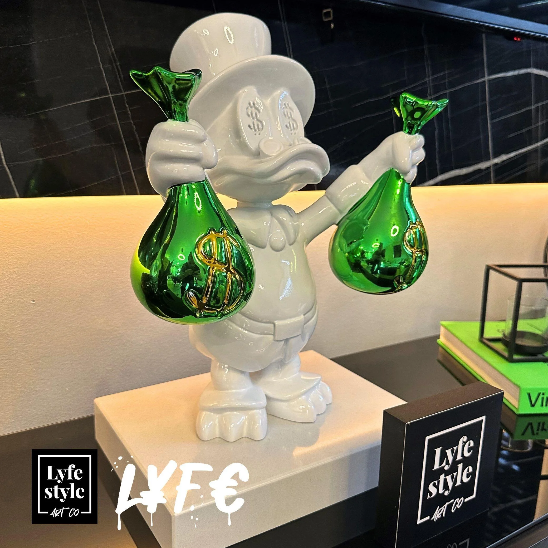 White duck figurine with dollar signs, holding green money bags.