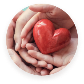 Multiple hands holding a red, heart-shaped object.