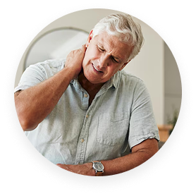 Man holding his neck, looking distressed in a home setting.