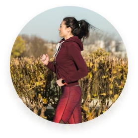 Person jogging outdoors in a red outfit, with greenery in the background.