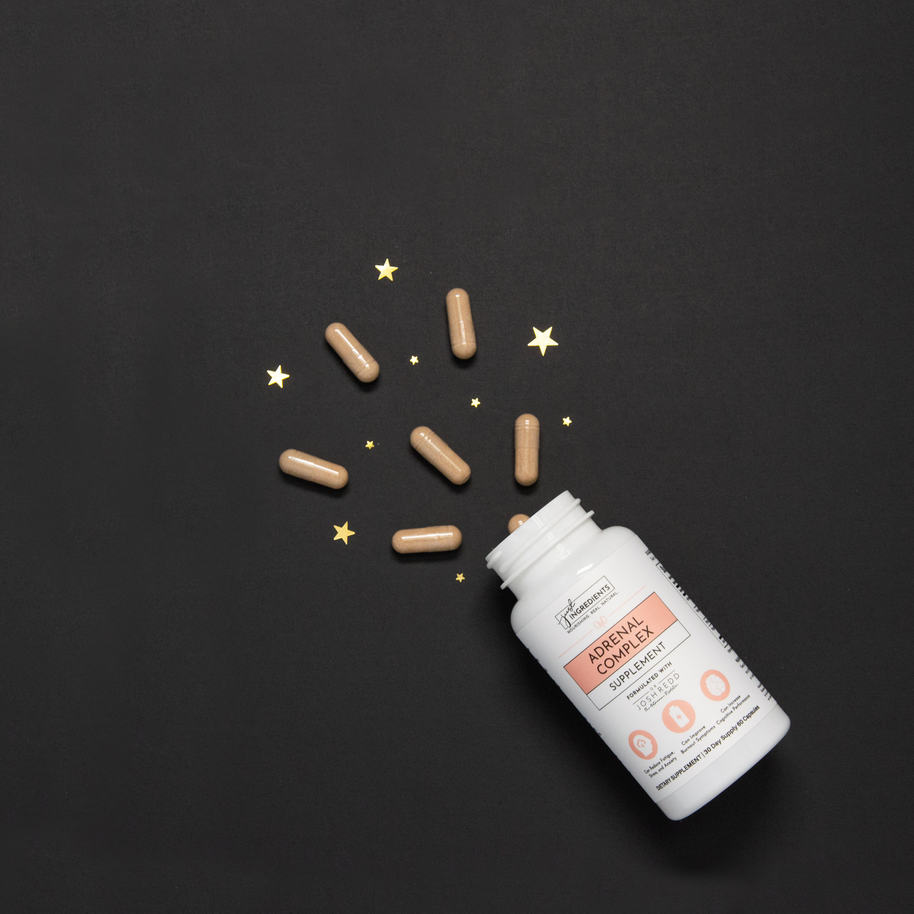 Supplement bottle with capsules and star decorations on a black background.