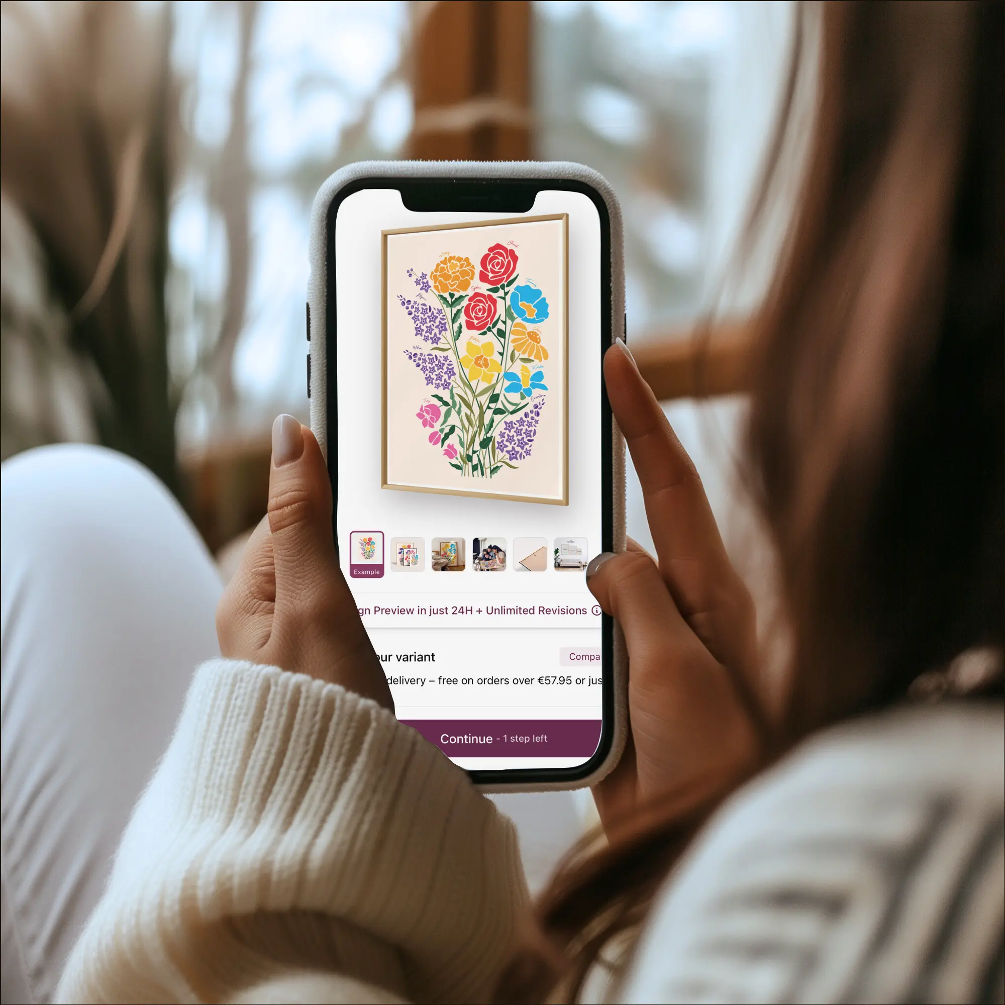 Person holding a smartphone displaying a colorful floral artwork.