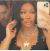 A person taking a mirror selfie, wearing a butterfly necklace.
