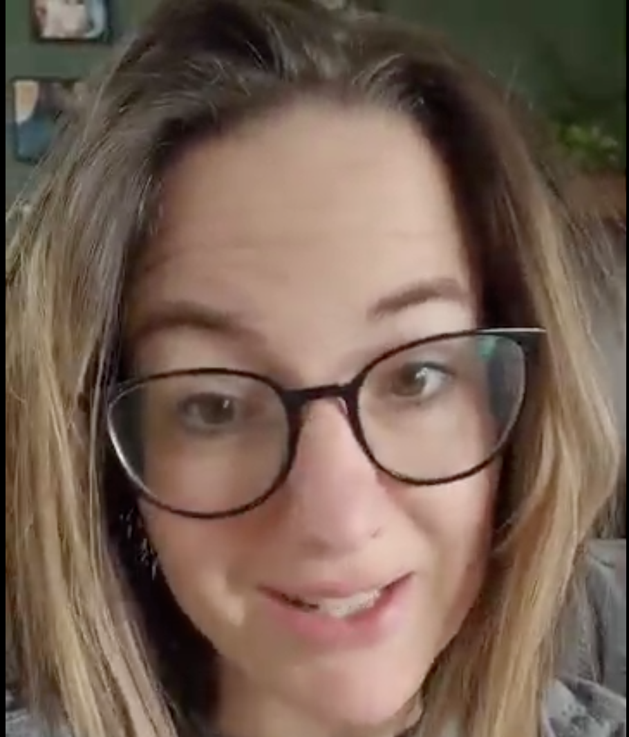 Person with glasses smiling at the camera.