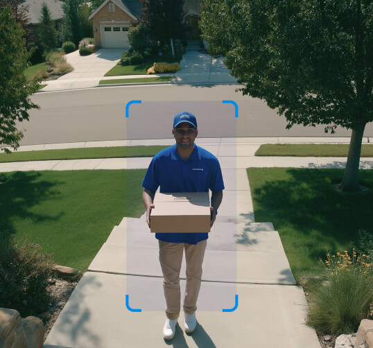 Delivery person holding a package on a doorstep, highlighted by an auto-tracking frame