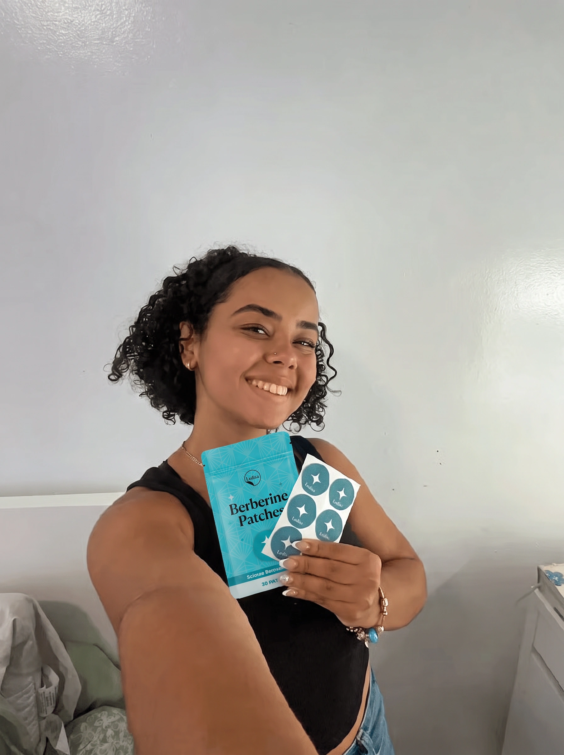 A smiling woman holds up a blue pouch of Berberine Patches and a sheet of the patches.