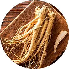 Ginseng roots on a wooden board, with a sliced piece nearby.