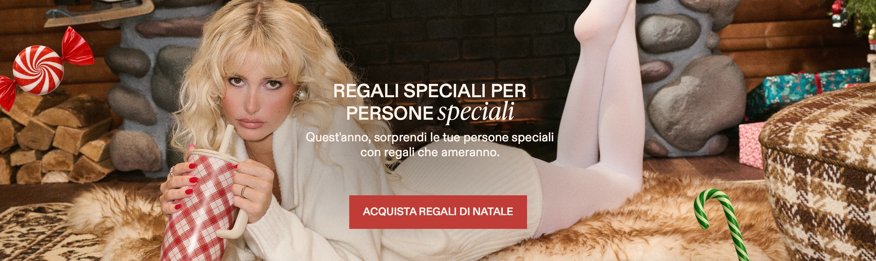 Person in cozy clothing holding a mug by the fireplace with gifts and candy around.