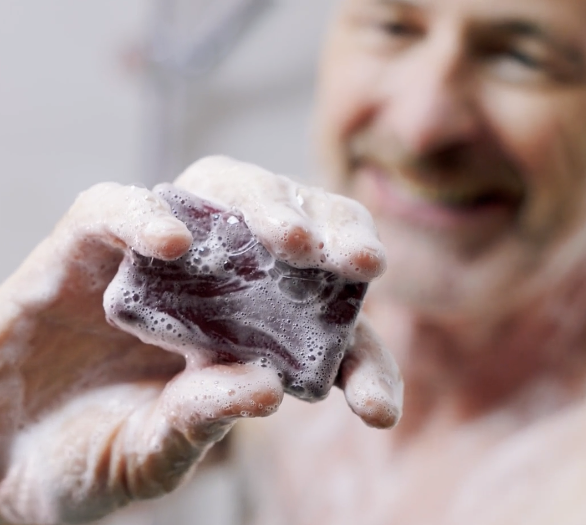 Person holding a soapy bar of soap.