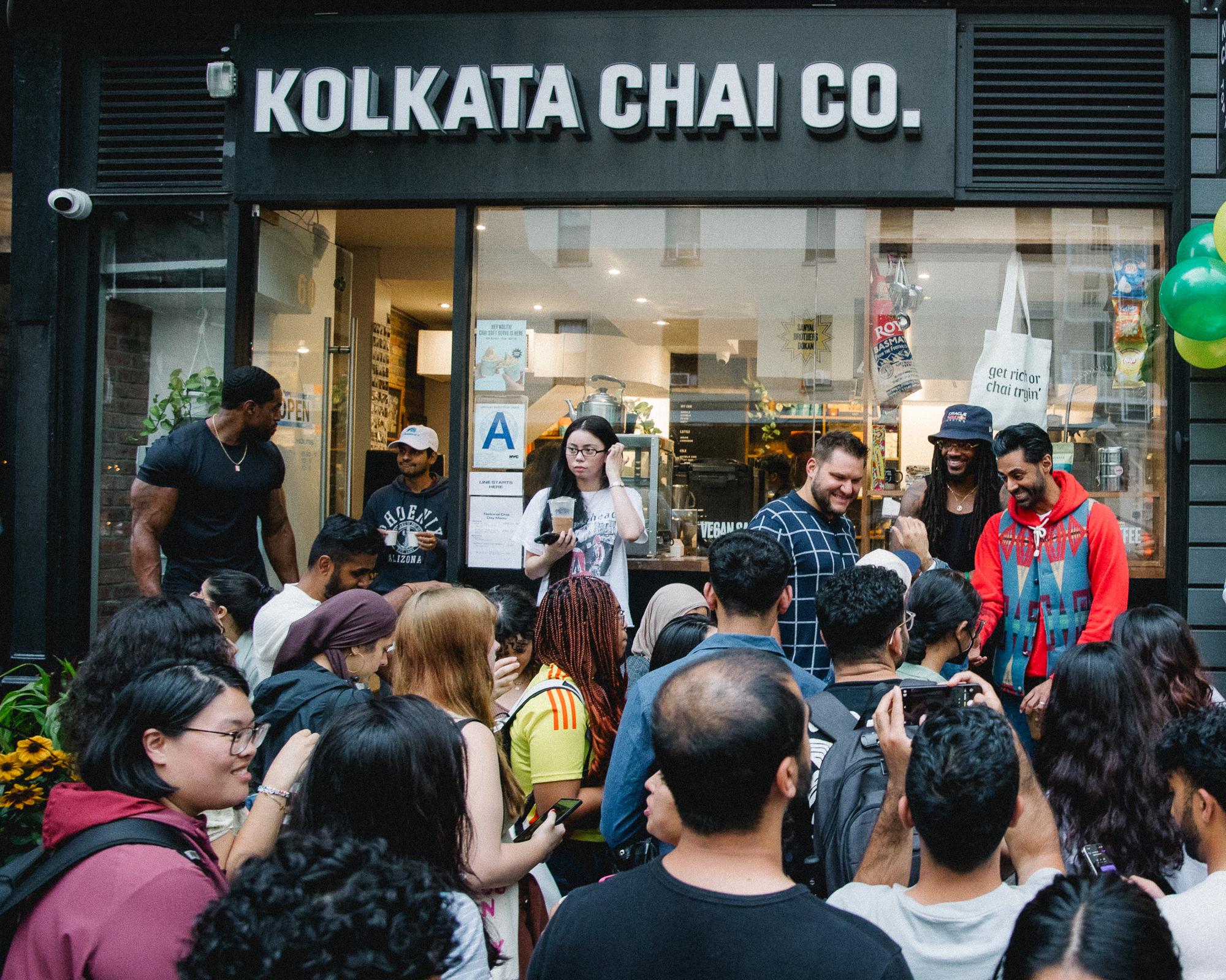 Crowd gathered outside Kolkata Chai Co. with people interacting and taking photos.