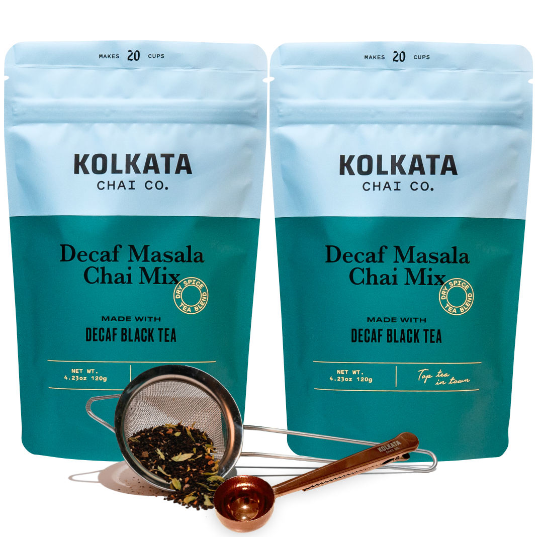 Two bags of decaf masala chai mix with a tea strainer and measuring spoon.