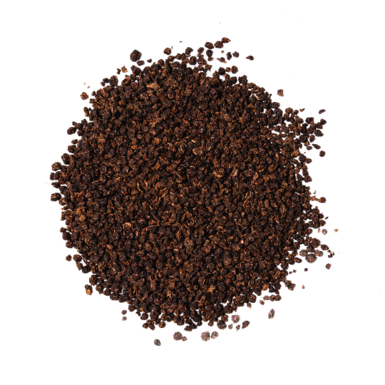 A circular pile of dark, granulated loose-leaf tea on a white background, viewed from above.