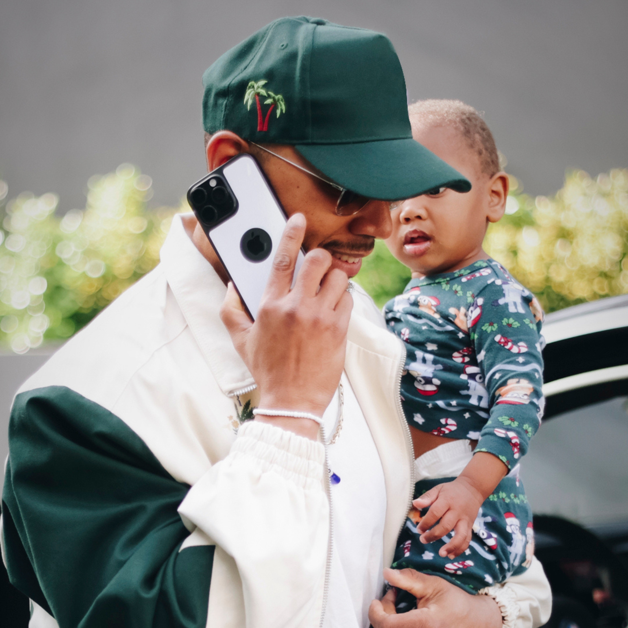 Man holding a child while talking on a smartphone.