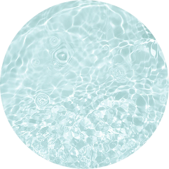 A circular close-up view of light blue water with ripples and bubbles on the surface.