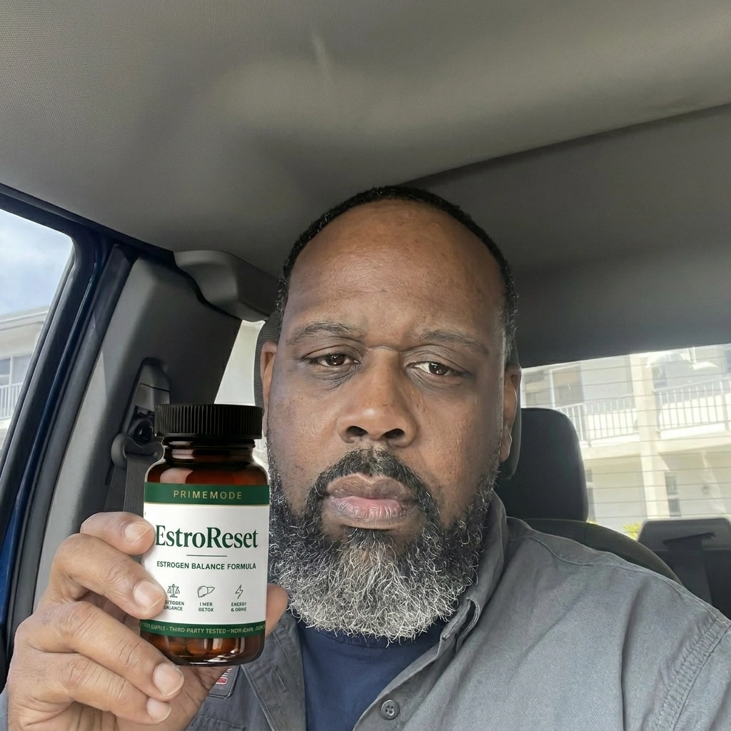 A man with a graying beard sits in a car, holding up a bottle of EstroReset supplements.