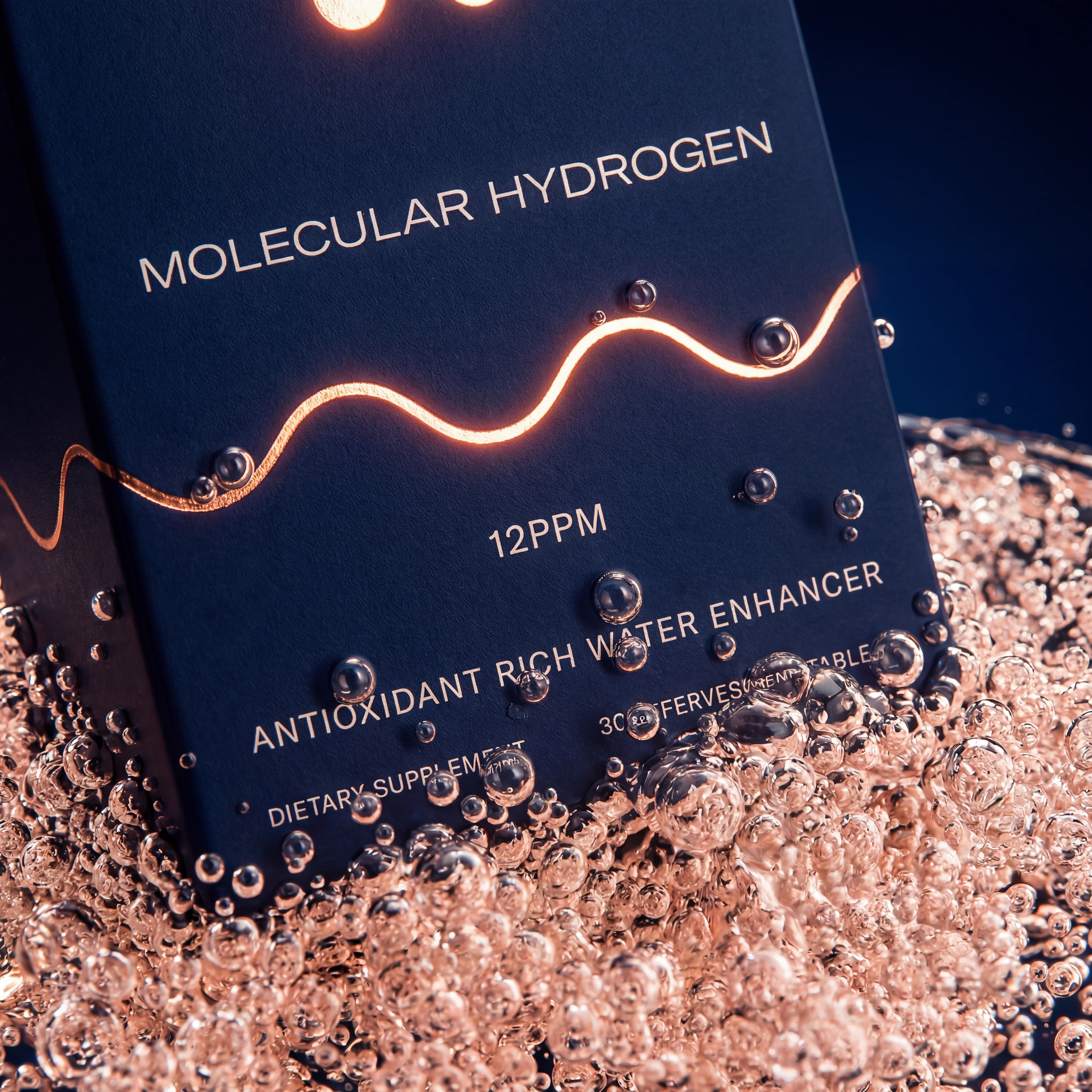 A close-up of a 'Molecular Hydrogen' supplement box sits partially submerged in bubbly, rose-gold colored liquid.
