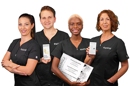 A group of four diverse skincare professionals in black uniforms posing with products and a certificate.