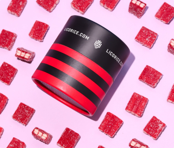Red and black striped container surrounded by red candy squares on a pink background.