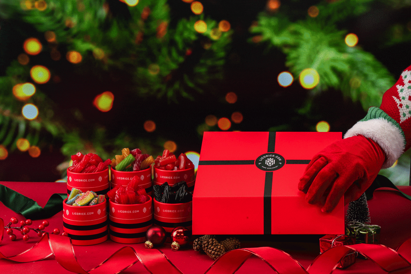 Red gift box and licorice containers with Christmas decorations.