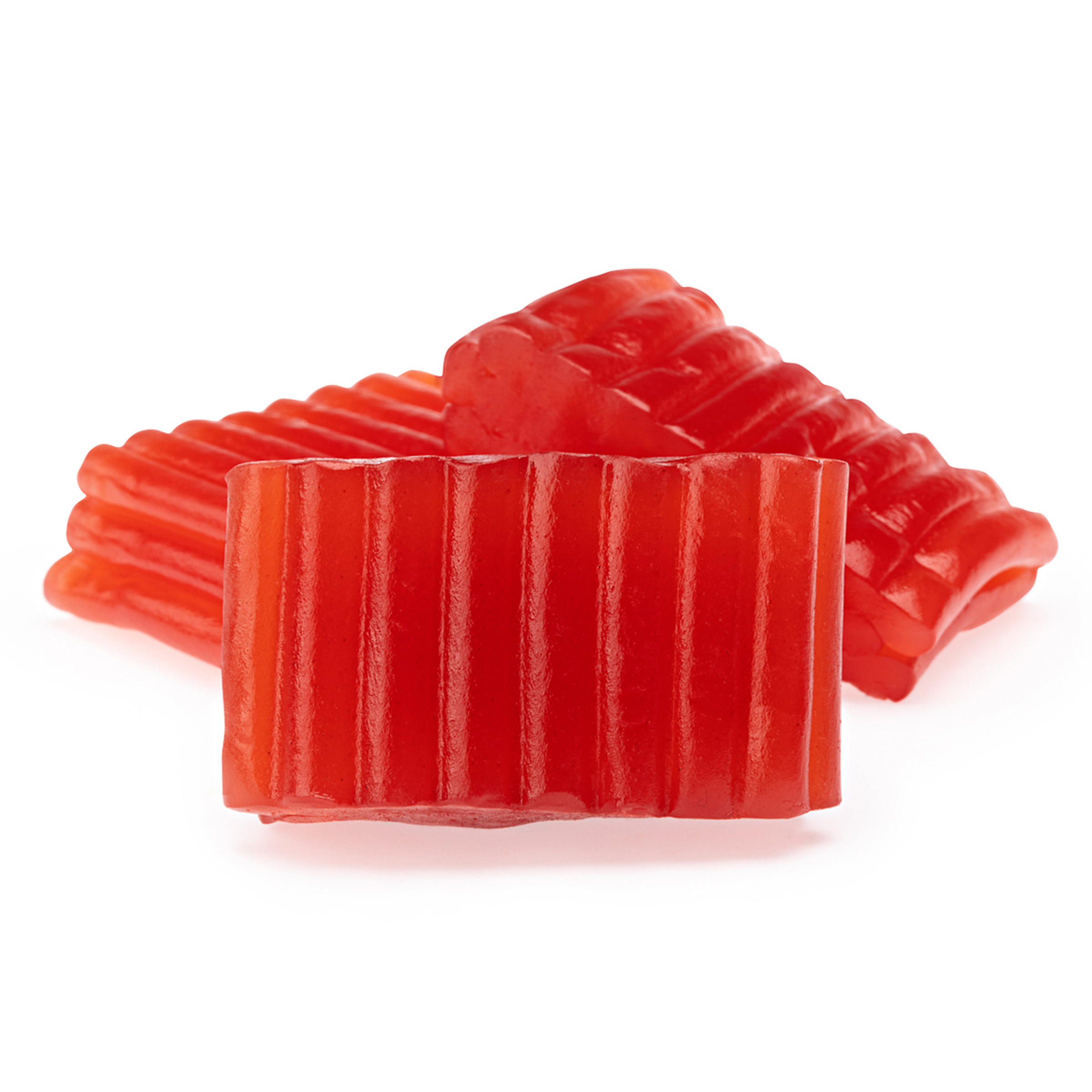Red, ribbed jelly candy pieces stacked together on a white background.