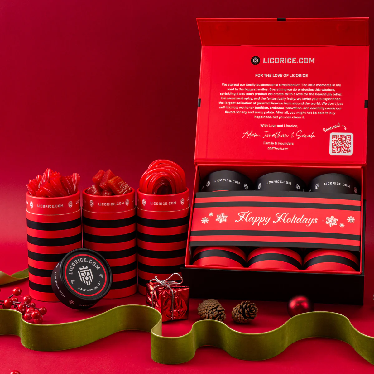 Red and black licorice gift set with holiday decorations on a red background.