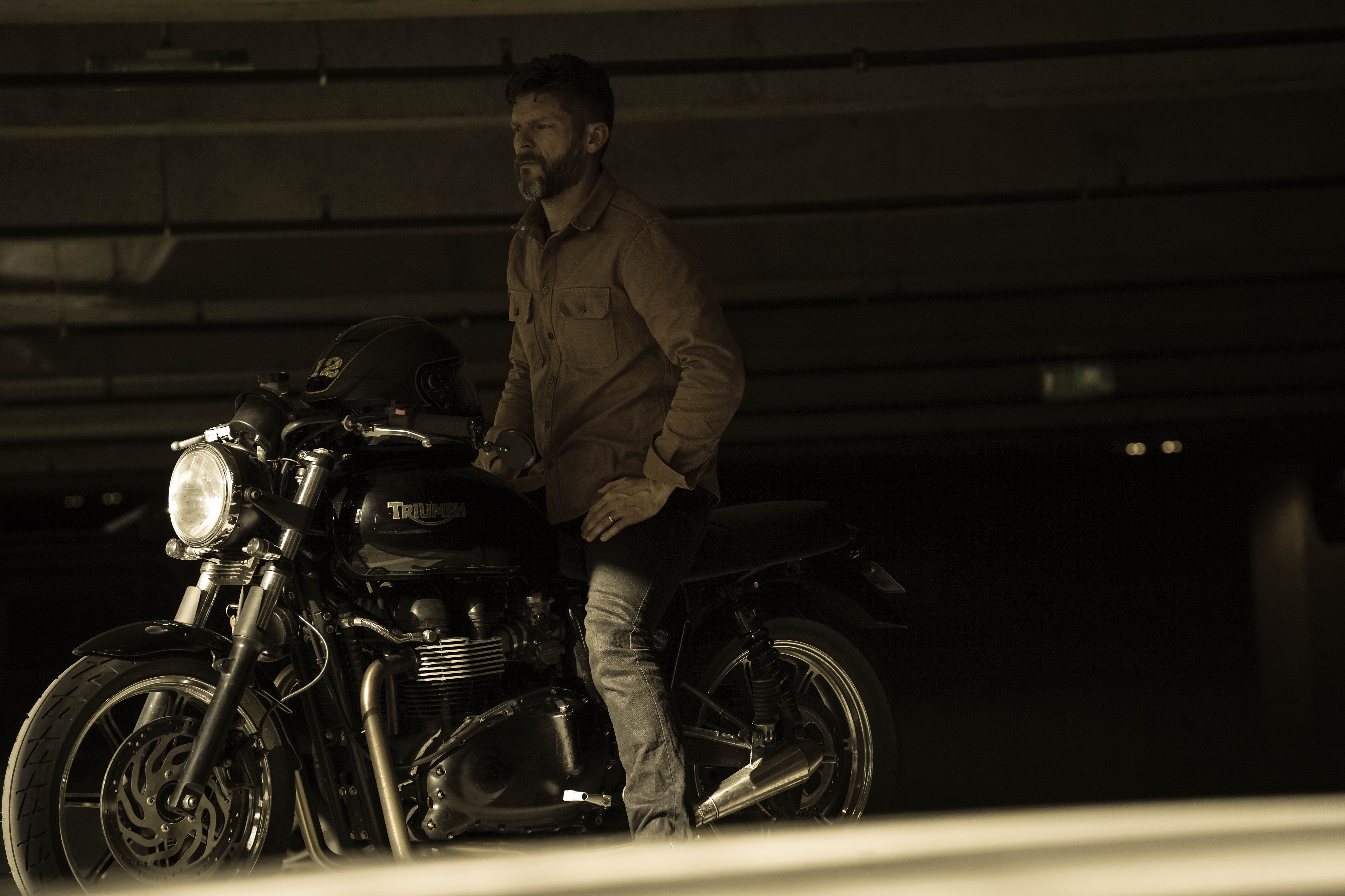 A person rides a motorcycle on a desert road at sunset.