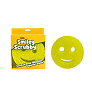 A yellow, circular smiley-face scrubbing sponge shown next to its product packaging on a white background.