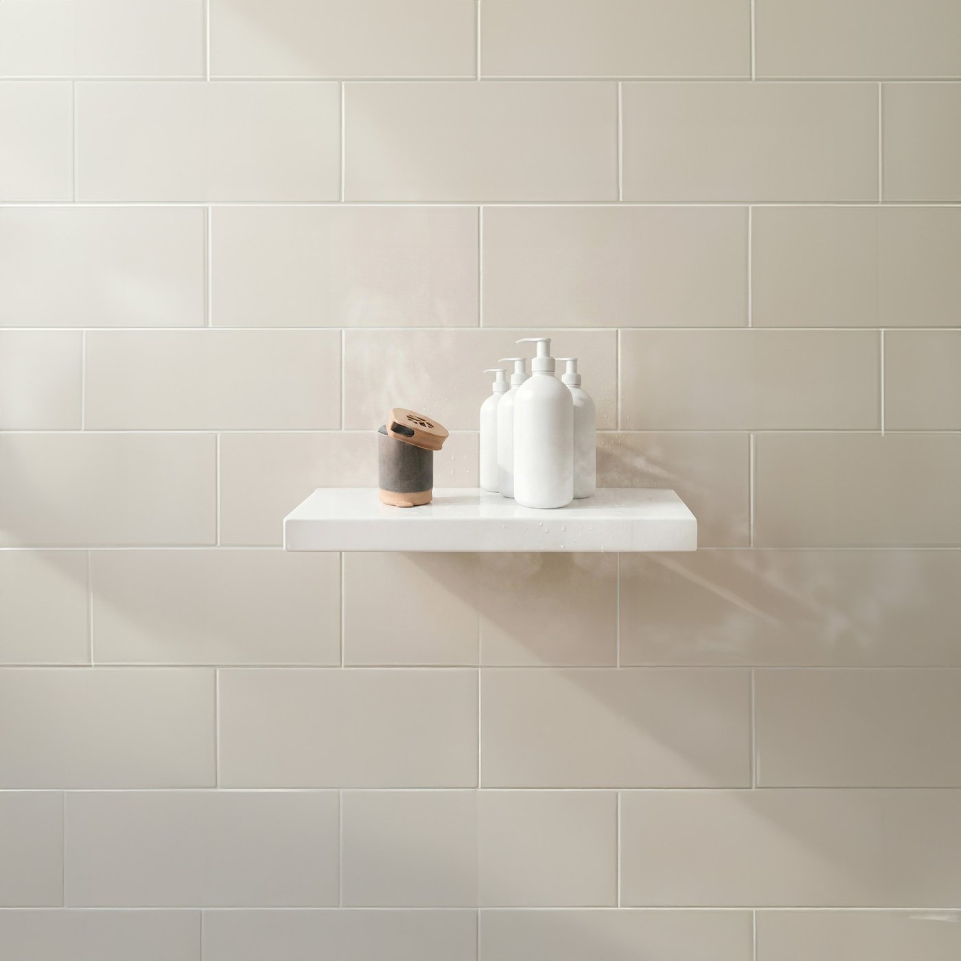 A Stem bar on a shower shelf beside shampoo and conditioner bottles