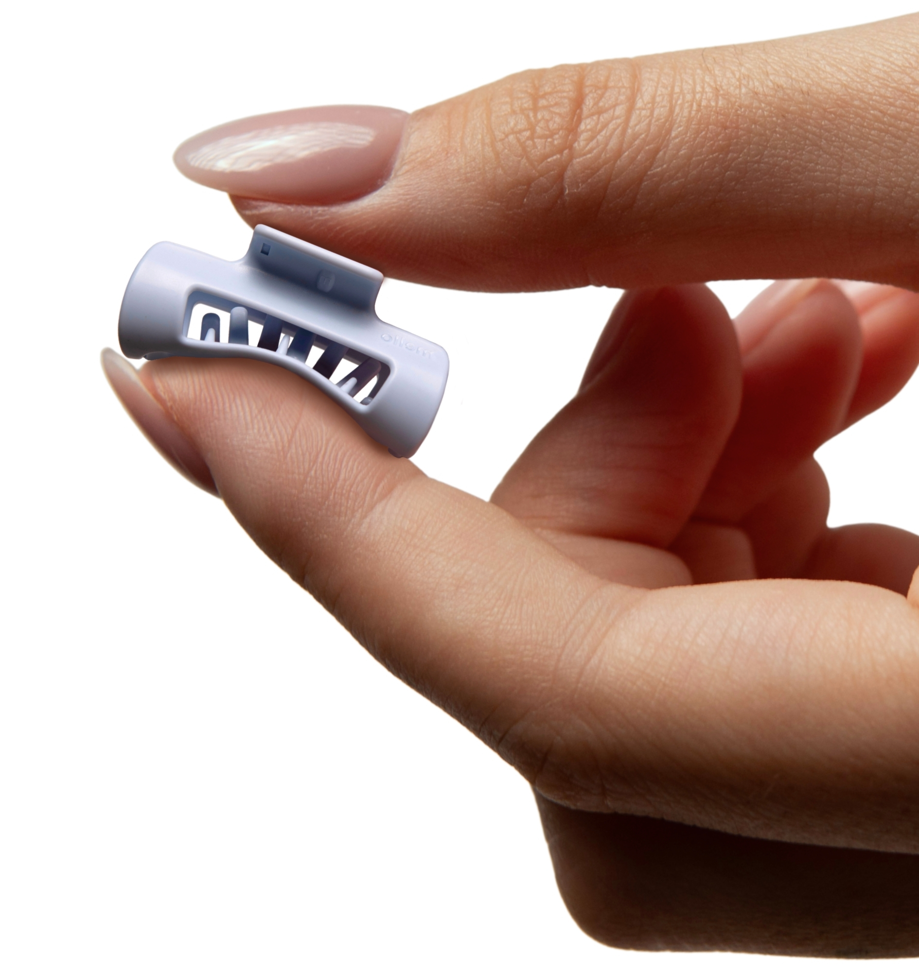 A close-up of a hand with polished nails holding a small, light blue plastic clip.