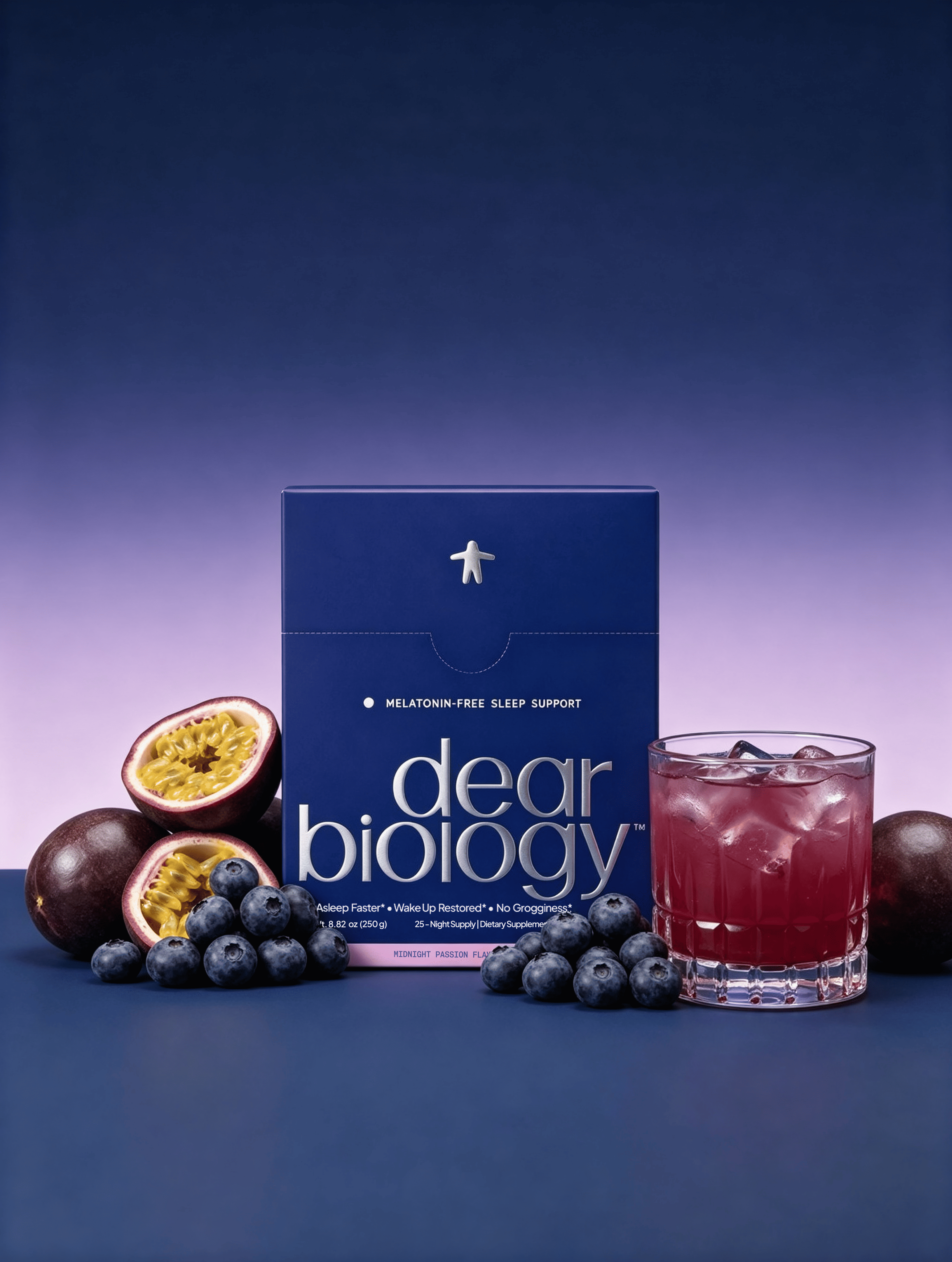 A box of Dear Biology sleep support with a drink, surrounded by blueberries and passion fruit on a blue surface.