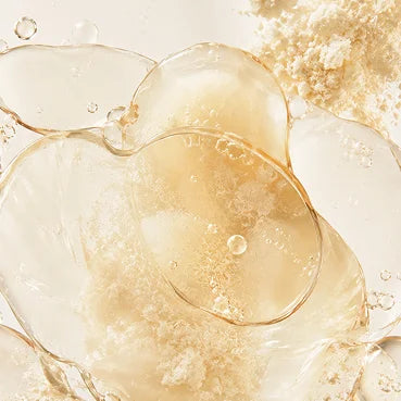 A macro shot of clear, yellowish liquid blobs mixed with a fine, light-colored powder.