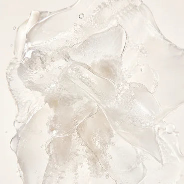 A close-up of a clear, textured gel forming petal-like shapes with bubbles against a white background.