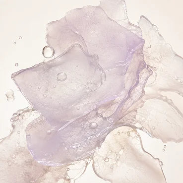 Close-up of translucent, layered purple and clear gel-like shapes with bubbles on a white background.