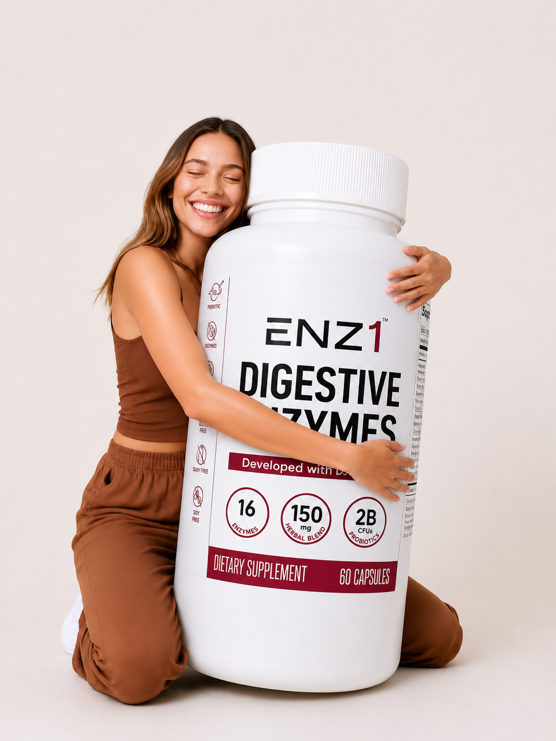 A smiling woman in a brown outfit happily hugs an oversized bottle of ENZ1 Digestive Enzymes supplements.