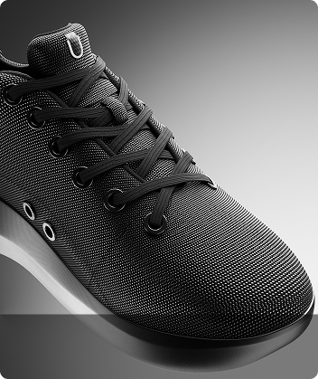Close-up of a black textured sneaker with laces and eyelets.