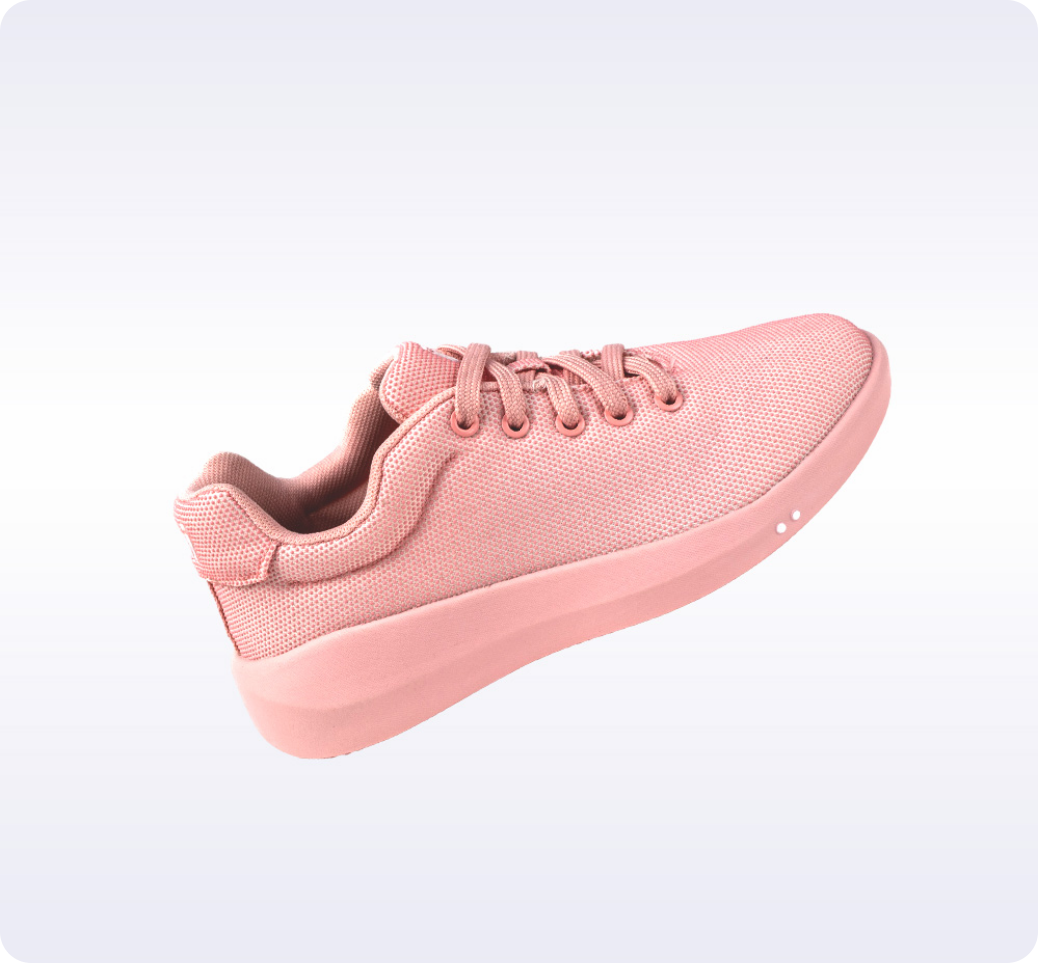 Pink sneaker with laces on a light gradient background.