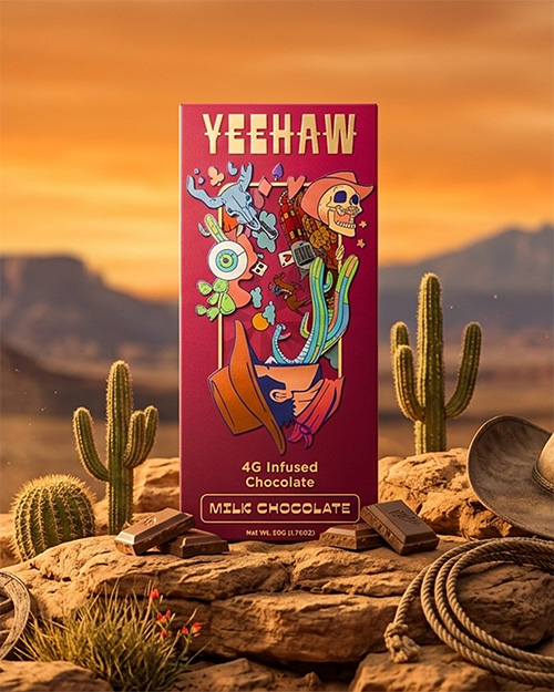 A Yeehaw brand milk chocolate bar with psychedelic western art, set in a desert landscape with cacti.