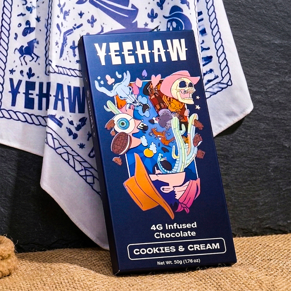 Three Yeehaw-branded packages with psychedelic western art floating over a desert highway under a pastel sky.