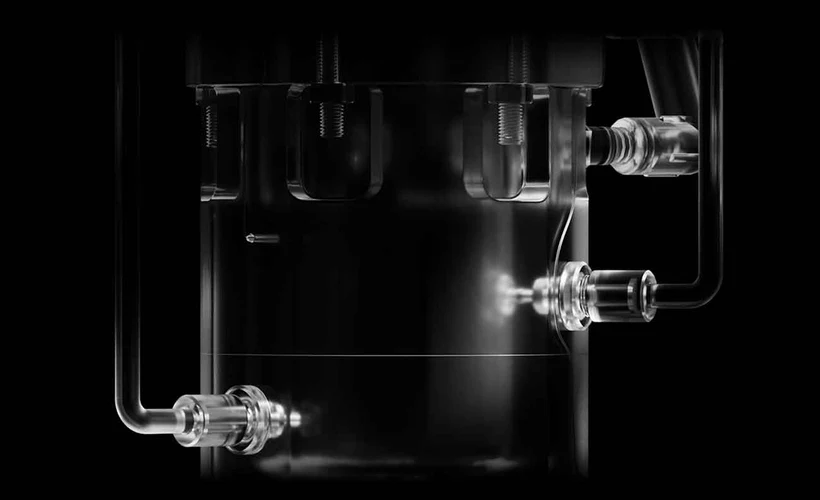 Close-up of a metallic industrial component with pipes and bolts.