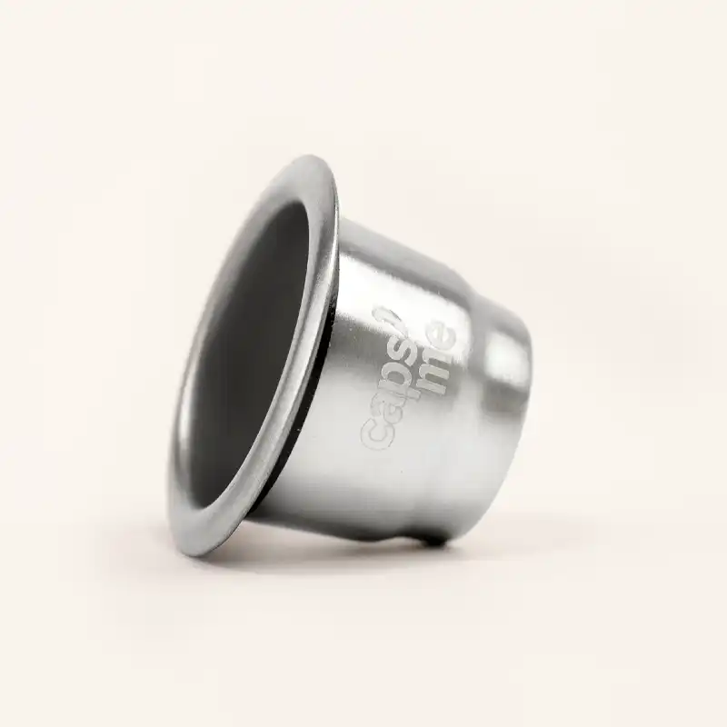 Silver metallic coffee capsule on a plain background.
