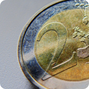 A close-up, cropped photograph of a 2 Euro coin on a plain surface.