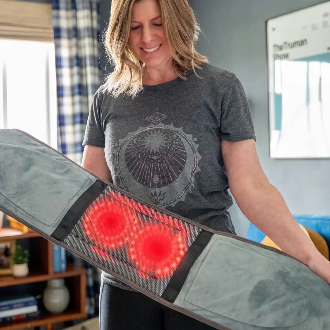 Person holding a massage belt with glowing red lights.