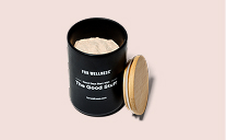 An open black canister of 'The Good Stuff' powder with its wooden lid resting against the side.