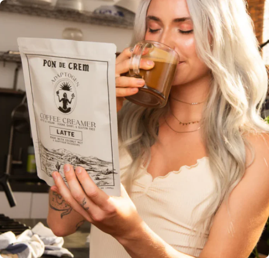 Person drinking coffee while holding a coffee creamer package.