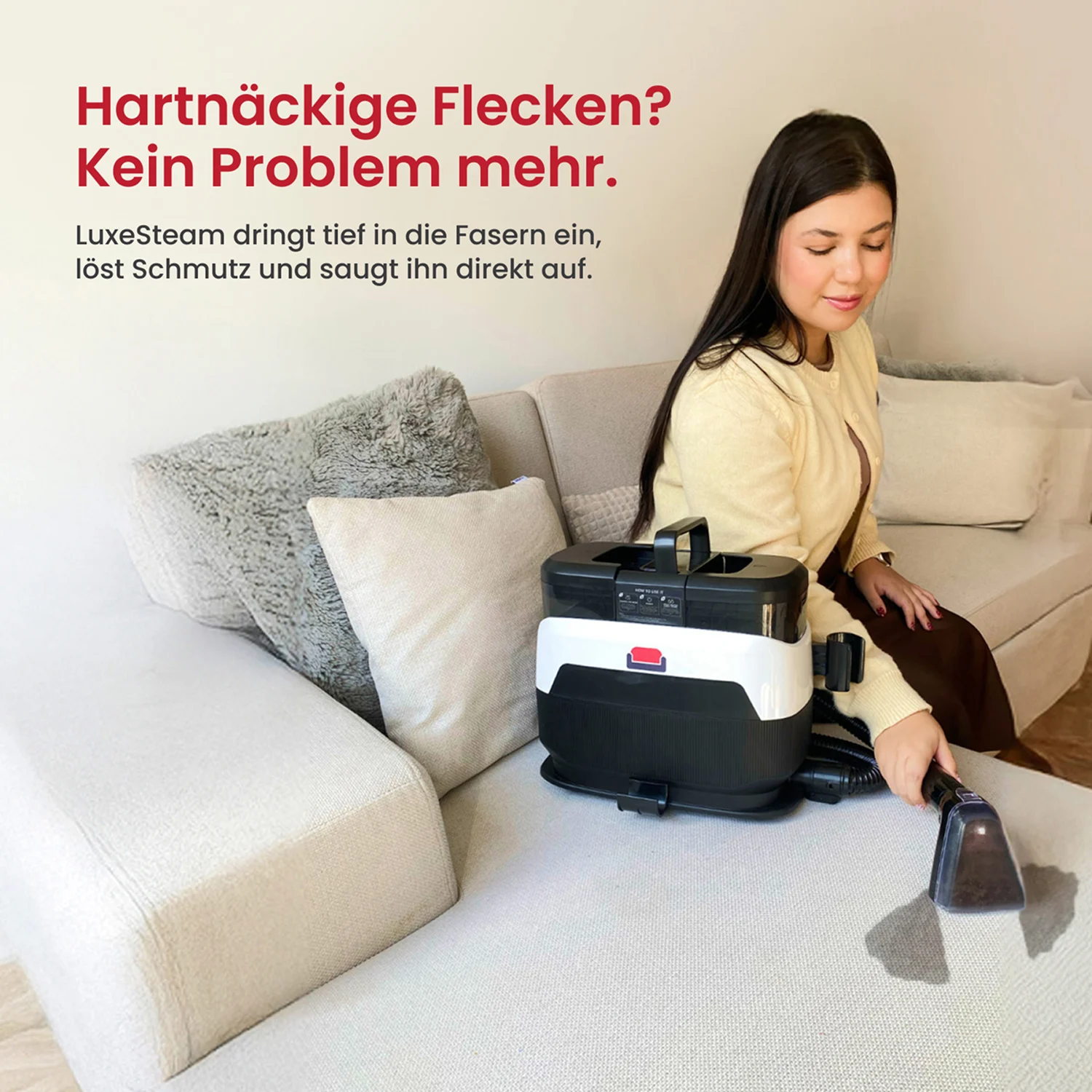 A woman uses a portable upholstery cleaning machine to remove a stain from a light-colored sofa.