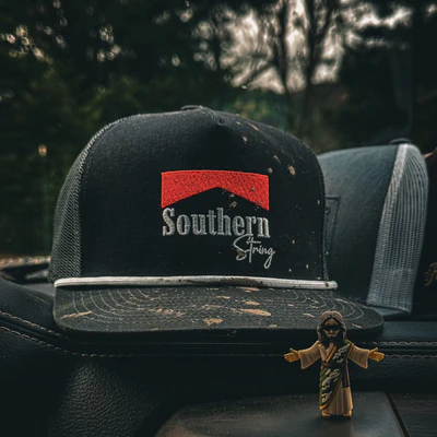 A cap with 'Southern String' logo and a small figurine in front.